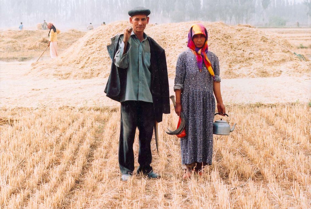 Uyghur farmers pose for a picture in front of hay bales, 2005. (Image by Todenhoff)