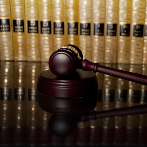 A judge's gavel resting in front of legal books.