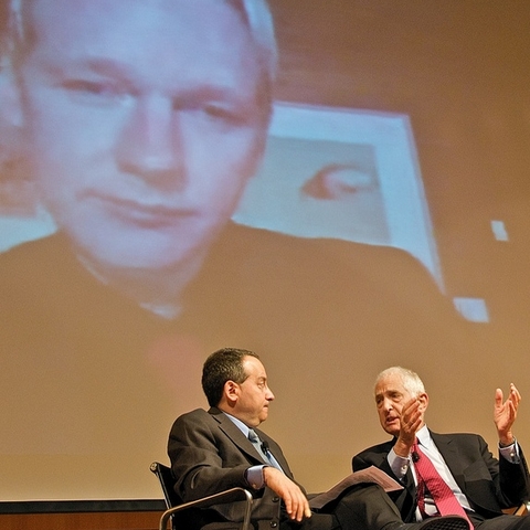 A projection of WikiLeaks founder Julian Assange looms over author Micah Sifry (left) and activist Daniel Ellsberg during a video conference in June 2010.